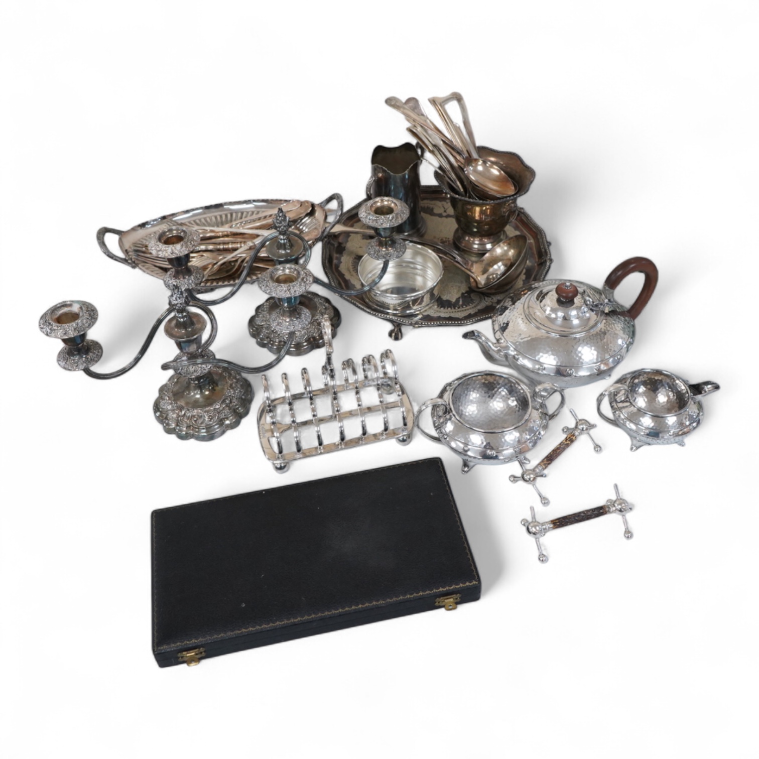 A collection of silver plate to include cased dessert forks, a hammered tea pot, pair of candlesticks and a salver